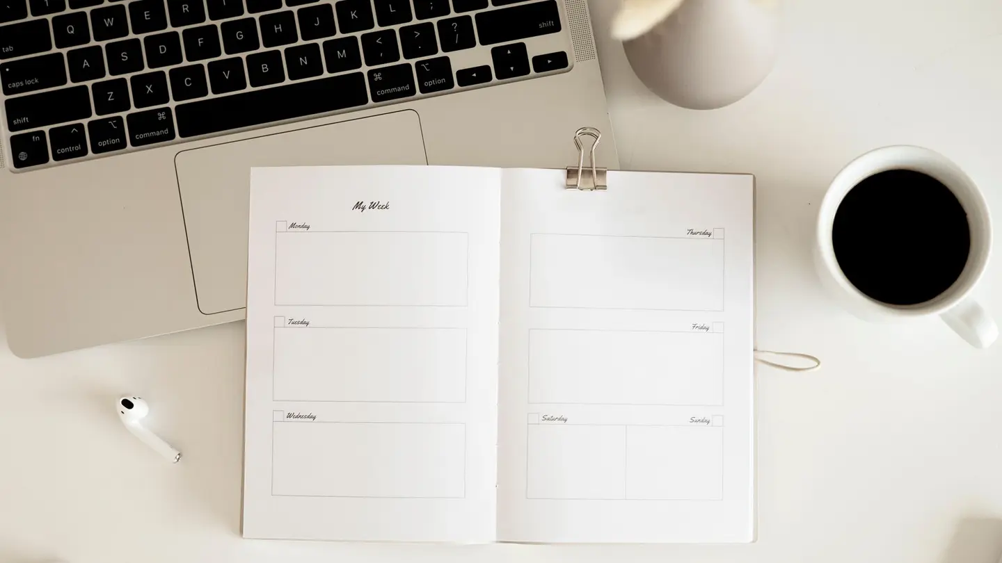 Una agenda semanal sobre la mesa junto a un café